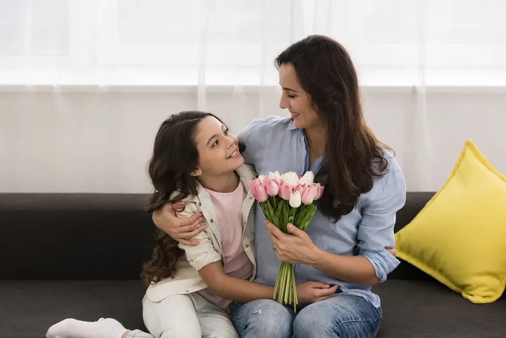 Daughter giving flowers on her mother to celebrate Mother's Day